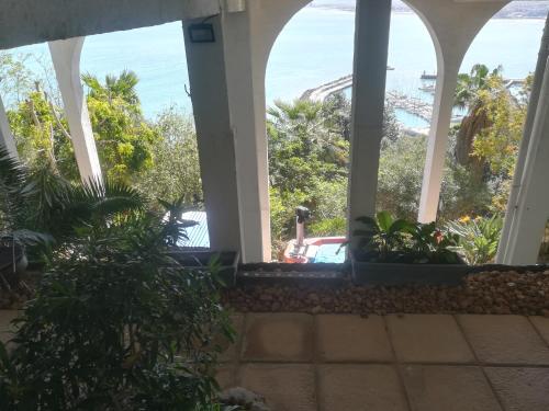 a car parked in front of a house with a view of the ocean at Harbourview Lodge in Gordonʼs Bay