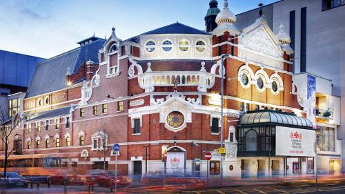 a large brick building with a clock on it at Holiday Inn Belfast by IHG in Belfast