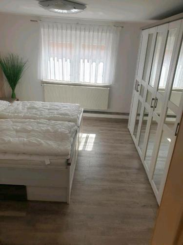 a bedroom with a white bed and a window at Störmthal Ferienwohnung 1 Sonnenweg in Störmthal