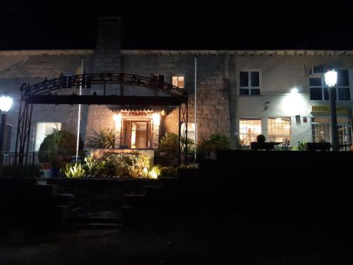 a house at night with lights in front of it at Hotel Sierra Oriente in Guadarrama