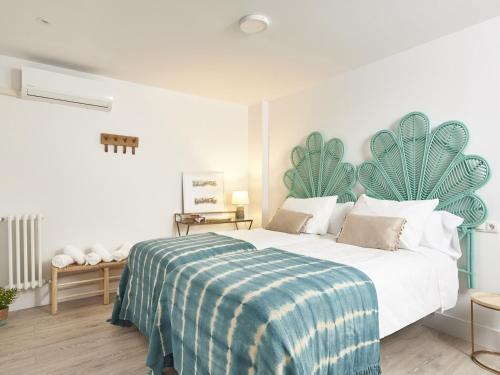 a bedroom with a bed with a blue and white blanket at Conde Alcalá Centro Parking Gratuito in Granada
