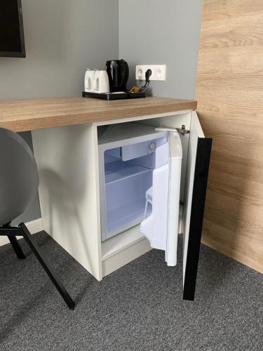 a desk with a small refrigerator under a table at Hugo in Gdynia