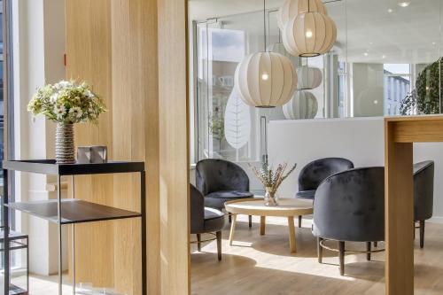a room with chairs and a table with flowers at Hotel Svendborg in Svendborg