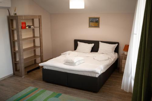a small bedroom with a bed with white sheets at Vikings Grigo Apartaments in Cluj-Napoca