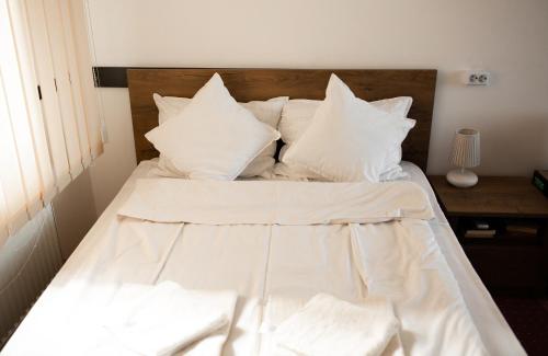 a white bed with white sheets and pillows at Viking Apartment Grigo in Cluj-Napoca