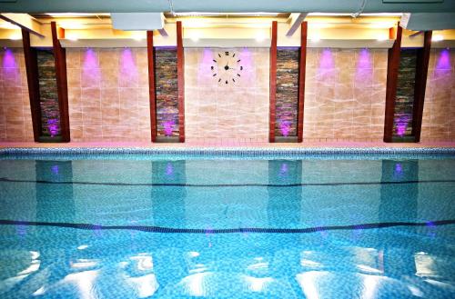 a swimming pool with a clock on the wall at Castle Green Hotel In Kendal, BW Premier Collection in Kendal