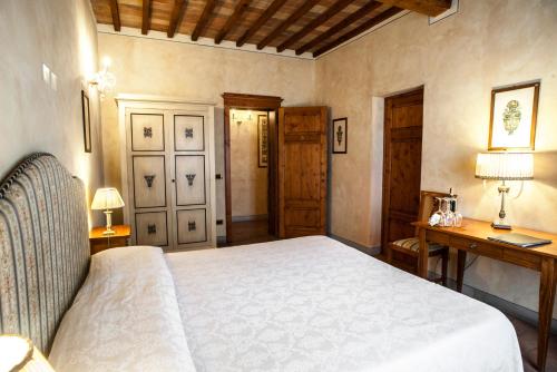 a bedroom with a bed and a desk and two lamps at B&B Palazzo Al Torrione in San Gimignano