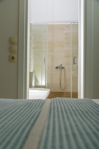 a bathroom with a shower with a toilet and a sink at Theasis Athens in Athens