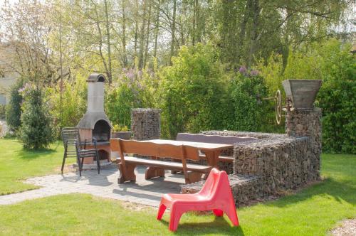 a picnic table and a stone fireplace in a garden at Hagwaldhof in Niederhofen