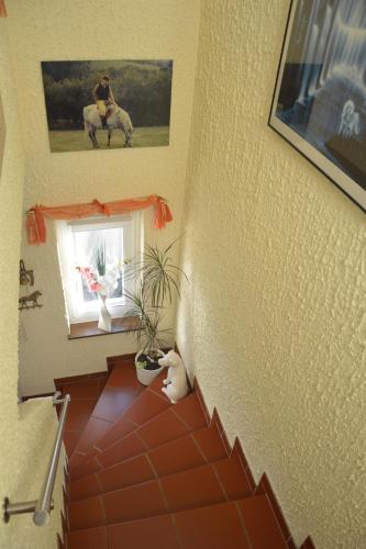 a room with a staircase with a horse picture on the wall at Ferienwohnung Auszeit Waxweiler in Waxweiler