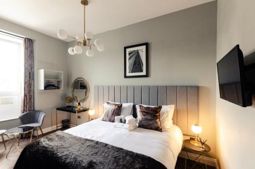 a bedroom with a large bed and a tv at Sweeney Motherwell in Motherwell