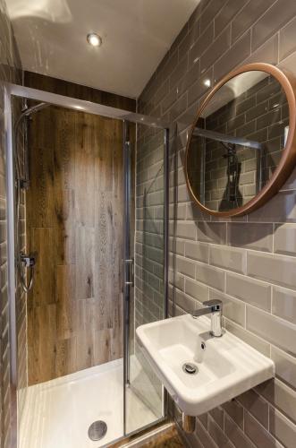 a bathroom with a sink and a shower and a mirror at Sweeney Motherwell in Motherwell