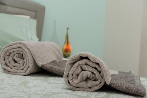 a pair of towels sitting on top of a bed at Theasis Athens in Athens