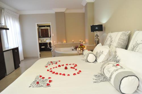 a bedroom with a bed with red roses on it at Adato Guesthouse in Potchefstroom