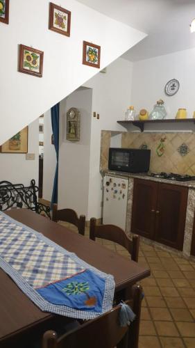 una camera con tavolo e una cucina con bancone di appartamento odeon a Taormina
