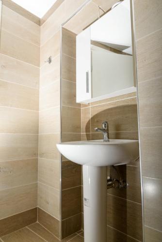 a bathroom with a white sink and a mirror at Theasis Athens in Athens