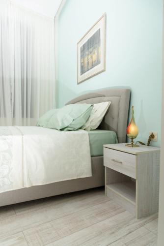 a bedroom with a bed and a table with a night stand at Theasis Athens in Athens