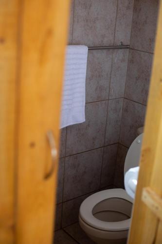 a bathroom with a toilet and a white towel at iLanga Lodge in St Lucia