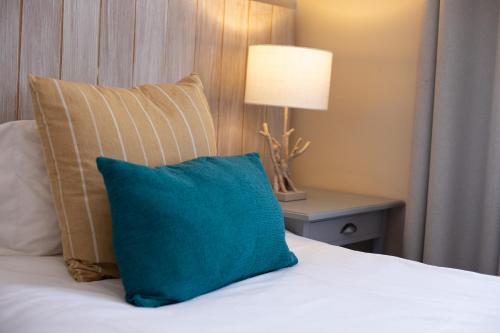 a blue pillow sitting on a bed with a lamp at iLanga Lodge in St Lucia