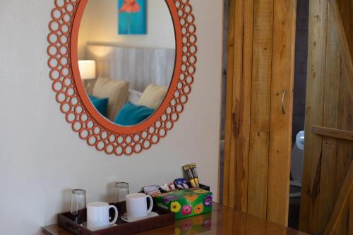 a mirror on a wall above a table with mugs at iLanga Lodge in St Lucia
