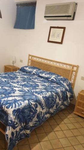 una camera con un letto e un piumone blu e bianco di appartamento odeon a Taormina