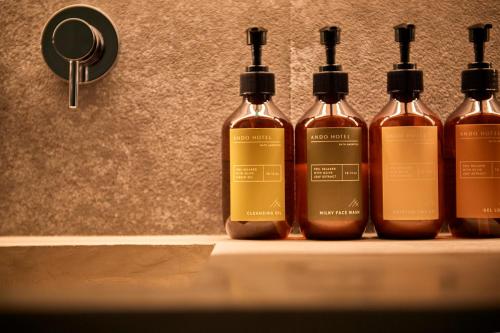 a group of four bottles of alcohol sitting on a shelf at ANDO HOTEL NARA Wakakusayama -DLIGHT LIFE & HOTELS- in Nara
