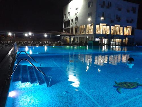 a swimming pool at night with a slide in it at Flamingo Resort in Belgrade