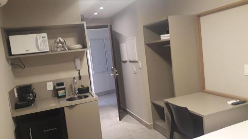una pequeña cocina con fregadero y una mesa en una habitación en Uno flats. N. 107. Luxo, en João Pessoa