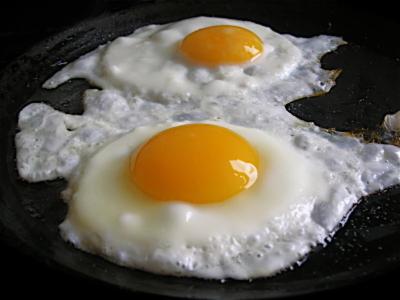 two eggs are cooking in a frying pan at Apfelblüte bed & breakfast 8 km vom Bodensee in Salem