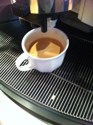 a cup of coffee sitting on a coffee machine at Apfelblüte bed & breakfast 8 km vom Bodensee in Salem