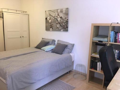 1 dormitorio con cama y estante para libros en Knus tuin-appartement vlakbij Nijmegen voor 2 personen, en Molenhoek