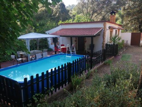 a house with a swimming pool in front of a fence at Las Solanas del Pilar in Córdoba