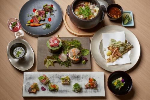 a table topped with plates of food and bowls of food at ANDO HOTEL NARA Wakakusayama -DLIGHT LIFE & HOTELS- in Nara