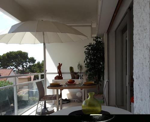 Cette chambre dispose d'un balcon avec une table et un parasol. dans l'établissement Super Bestouan, à Cassis