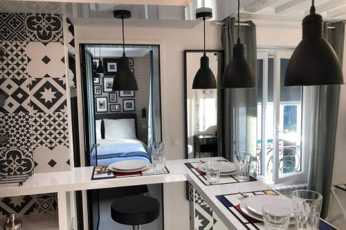 - une cuisine avec une table avec un miroir et un lit dans l'établissement Appartement Rousselet Quartier Bon Marché Paris VIIème, à Paris