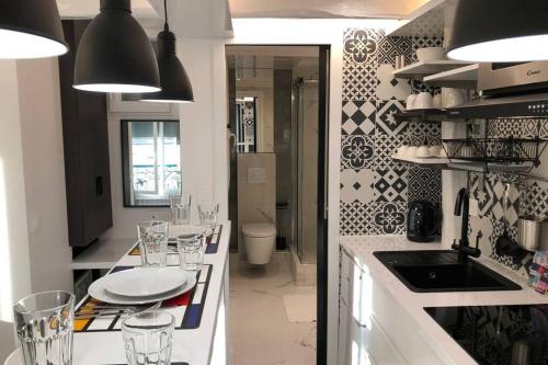 une cuisine avec un comptoir et des lunettes dans l'établissement Appartement Rousselet Quartier Bon Marché Paris VIIème, à Paris