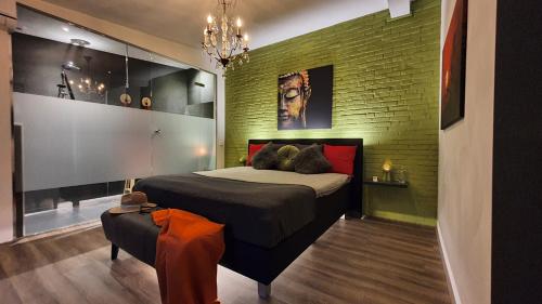 a bedroom with a bed and a green brick wall at Downtown Hideaway, B&B Grand Deluxe in Eindhoven