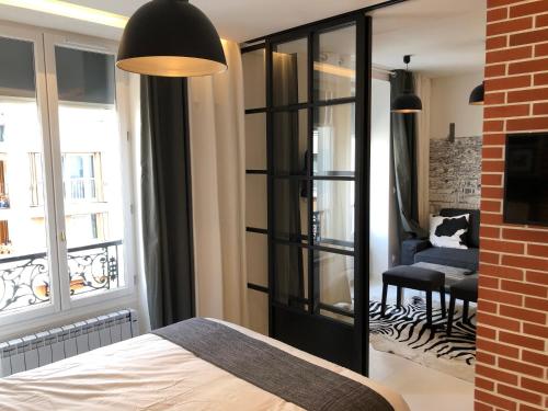 une chambre avec un lit, une fenêtre et une chaise dans l'établissement Appartement Hainaut Paris XIXème- Tout Equipé!, à Paris