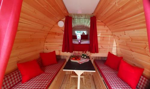 a small room with red cushions and a table in a tiny house at Schlaffass in Neumark