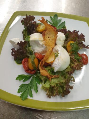 a green and white plate of food on a table at Hotel Rose in Villabassa