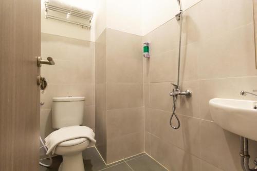 W łazience znajduje się prysznic, toaleta i umywalka. w obiekcie Front One Residence Syariah Mampang w Dżakarcie