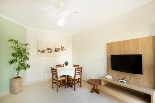a dining room with a table and a flat screen tv at Vinhedo Plaza Hotel in Vinhedo