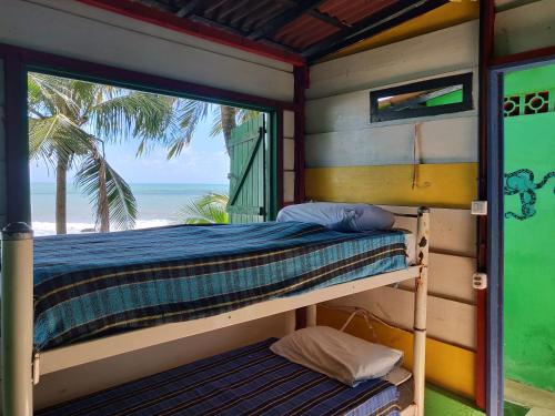 a bed in a room with a view of the beach at Hostel Casa de Jack in Pipa