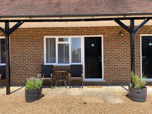 a brick house with a table and chairs in front of a door at Kings Head Inn in Rye