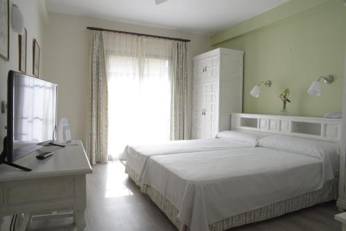 a bedroom with a large white bed and a window at TRH Mijas in Mijas