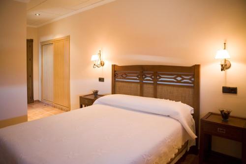 1 dormitorio con 1 cama blanca grande con luces en la pared en Hotel-Restaurante Cerrillo San Marcos, en Diezma