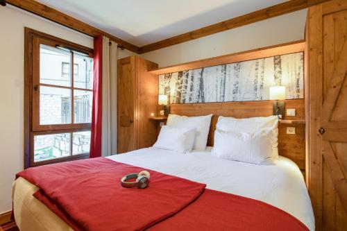 a bedroom with a bed with a red blanket at Résidence Pierre & Vacances Premium Arc 1950 Le Village in Arc 1950