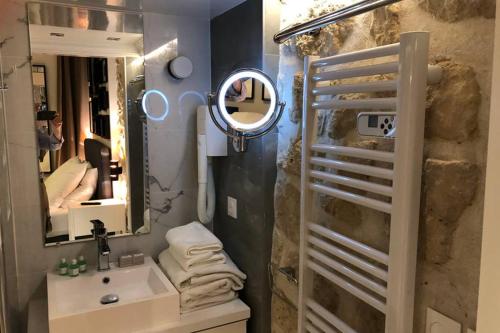 une salle de bain avec un lavabo et un miroir dans l'établissement Loft Nazareth Quartier du Marais, à Paris