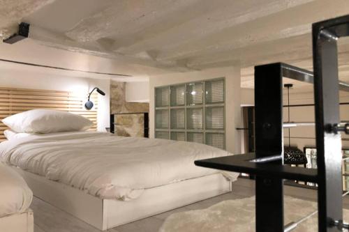 une chambre avec un lit blanc et un bureau dans l'établissement Loft Nazareth Quartier du Marais, à Paris