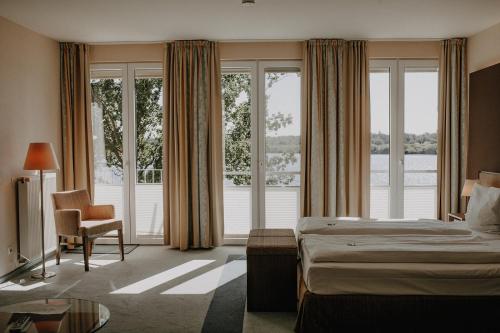 ein Hotelzimmer mit einem Bett und einem großen Fenster in der Unterkunft Hotel Seeblick in Thülsfeld